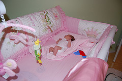 Pink crib with baby and mobile toys