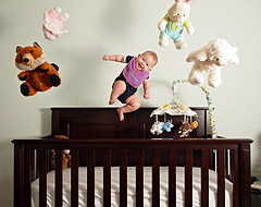 Wooden brown crib with baby and stuff toys