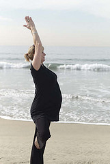 Pregnant mom doing yoga along the shore